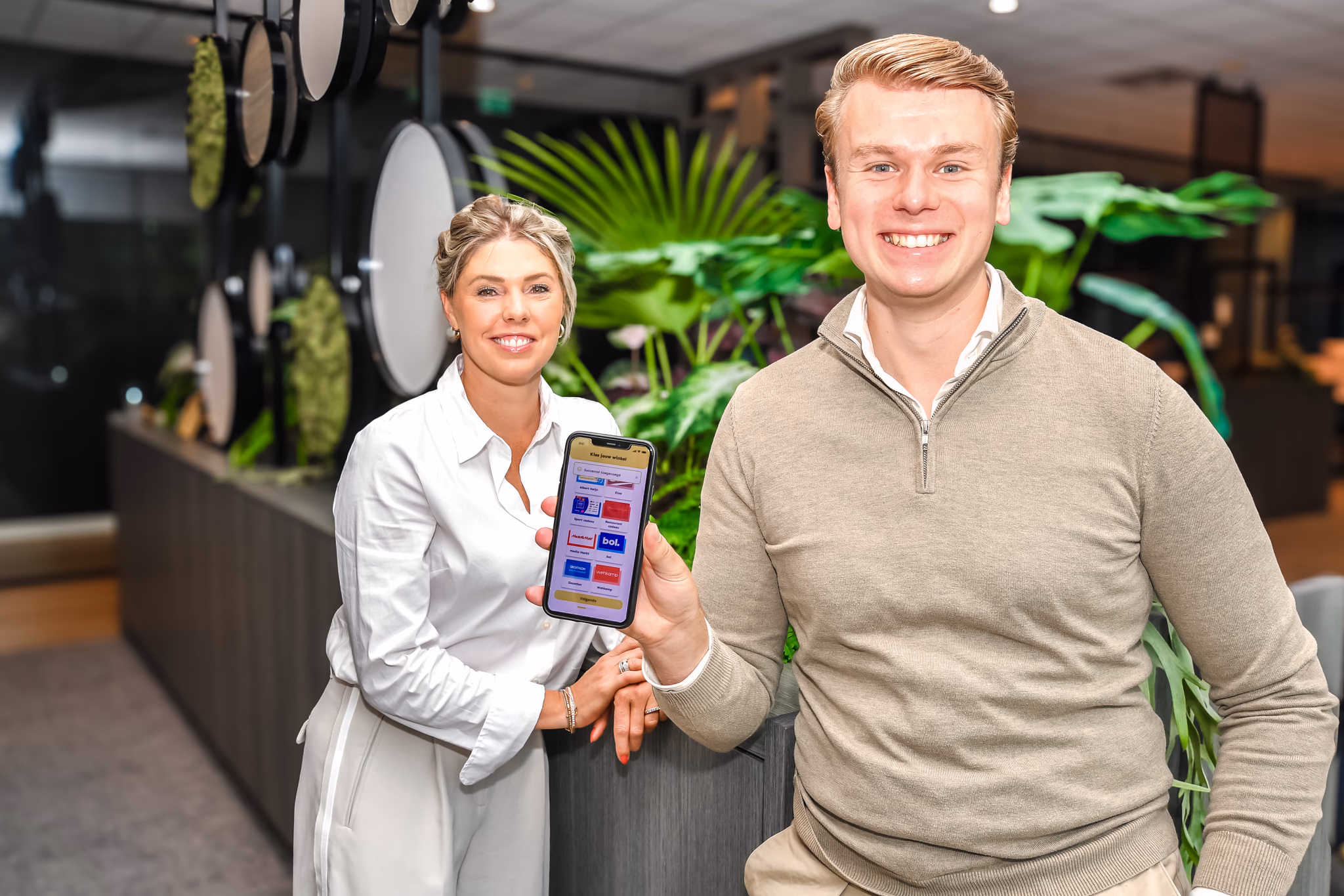 Twee medewerkers met de Taxvrij app op een telefoon.
